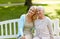 Daughter with senior mother hugging on park bench