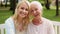 Daughter with senior mother sitting on park bench