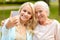 Daughter and senior mother taking selfie at park