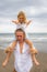 Daughter sitting on father`s shoulders. Father and daughter playing together at the beach. Happy family. Having fun together.