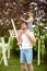 Daughter sitting on father`s shoulders picking cherries, smiling