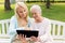 Daughter with tablet pc and senior mother at park