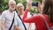 Daughter taking photo of her senior parents on vacation trip in Paris. Happy family enjoying vacation