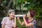 Daughter talking to hearing impaired elderly woman , using paper tube