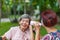 Daughter talking to hearing impaired elderly woman , using paper tube