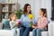 daughters giving flowers and gift to happy mother