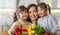 Daughters giving mother bouquet of flowers