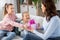 daughters giving present to happy mother