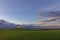 Dawn light across the large wheat field of a Scottish Farm with the Montrose Basin in the background.