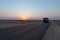 Dawn light in desert sky with empty road passing through the desert. Wind mills in the horizon, Sun rise at Thar desert, Rajasthan