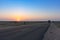 Dawn light in desert sky with empty road passing through the desert. Wind mills in the horizon, Sun rise at Thar desert, Rajasthan