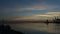 Dawn in the seaport. Boats and yachts sway on the waves at the pier, a large cargo ship swims out of the port