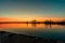 Dawn in a seaport with a crimson red cloudy sky and a reflection