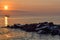 Dawn at the seaside. Rocks, sea, boat. Greece, Halkidiki, Kassandra