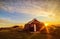 Dawn on the shore of the Atlantic Ocean. A traditional old house with a roof overgrown with grass and a tent on the beach. Iceland