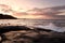 Dawn on the shore of the Atlantic Ocean. Waves crash against the rocky shore and the island in the background Atlantic Ocean. USA.