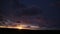 The dawn sky is tinged with shades of amber, as the sun creeps over the horizon. A mesmerizing timelapse captures the gradual