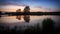 Dawn on the Ural lake with trees on the shore in June, Russia, Ural