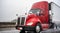 Day cab big rig red semi truck with roof spoiler transporting cargo in refrigerated semi trailer running on the wet rain highway