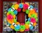 Day of the Dead wreath on door with tree and neighborhood reflected in beveled glass window