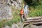 Day hikers, woman and man crossing trail over a rocky slope