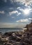 Day landscape with rocks washed by the sea and the rays of the s