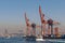 Day shot of the cranes in the shipyard of the Port of Haydarpasha, and passing ferry boat with background view of Istanbul, Turkey