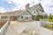 Day shot of a wonder California home with a large deck and seating area on a bright sunny day with puffy clouds