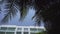 Day time exterior establishing shot of generic hotel condo or apartment building in tropical location with palm trees
