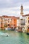 Day view of canal in Venice, houses and boat