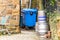 Day view of stacked beer casks of kegs at the back of the pub with recycly bin and shopping trolley next to it