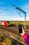 Day view of woman hand holding smartphone over UK Railroad.