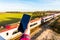 Day view of woman hand holding smartphone over UK Railroad.