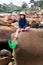 Daydreaming kid unhappy or bored to sit on granite stone