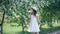 Daydreaming young girl standing under blooming spring trees