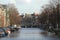 A daylight scene in the city center of Amsterdam, Holland - canal with boats and bridge