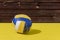 daylight. very bright sun. Retro yellow wooden background. The volleyball ball broke completely