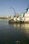 Daytime view of tug boat pushing barge down Mississippi River in front of Gateway Arch and skyline of St. Louis, Missouri as seen