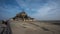 Daytime wide angle view mont st michel at low tide showing the mud flats.