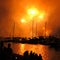 Dazzling fireworks orange dust over harbor landscape with people watching