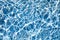 De-focused blurred transparent blue colored clear calm water surface texture with splashes.