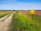 A Dead End sign posted along a rural gravel road.