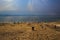 Dead Sea Jordan 20-09-2017. A wide beach with pebbles and sand leads to the dead sea in a strange sky that makes light rays shine