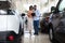 Dealership Center. African American Customers Couple Purchasing Car In Showroom