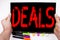 Deals text written on tablet, computer in the office with marker, pen, stationery. Business concept for Advertising Deal white bac