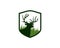 Dear head with antlers in front of meadow grass inside crest shield logo