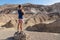 Death Valley - Man with scenic view of colourful multi hued Amargosa Chaos rock formations in Death Valley National Park, USA