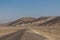 Death Valley - Panoramic view of endless empty road leading to colorful geology of multi hued Artist Palette rock formations