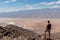 Death Valley - Rear view of man overlooking the Salt Badwater Basin and Panamint Mountains seen from Dante\'s View
