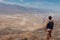 Death Valley - Rear view of man overlooking the Salt Badwater Basin and Panamint Mountains seen from Dante\'s View